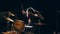 Slow-motion view of flowing black hair - young female plays drum rock at garage, slow-motion