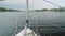 Slow motion view from yacht fore on river-bank and water. Close up of bowsprit and jib furler