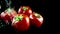 Slow motion of water splash on red tomato on black background, concept of healthy food