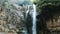 Slow motion of a waterfall under heavy rain, water falls down in Georgia in summer