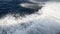 Slow motion wave trails sea foam on ocean moving speedboat