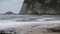 Slow motion of waves of the atlantic ocean in cloudy rainy weather on the background of the cliff