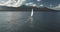 Slow motion of yacht, wind blows to sail at ocean aerial. Mountain island of Arran, Scotland, Europe