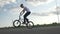 Slow motion of young biker pedaling and jumping practicing mid air moves with bike outside in the street -
