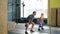 Slow motion of young couple exercising in gym squatting with kettlebells working out