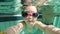 Slow motion of young girl swimming underwater with goggles