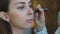 Slow motion of young make-up artist makes a girl beautiful makeup closeup before an important event