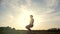 Slow-motion - young male parkour tricker jumper performs amazing flips in front of the sun
