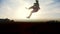Slow-motion - young male Parkour tricker jumper performs amazing flips in front of the sun
