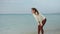 Slow motion of young woman runs on sandy sea beach, stops and takes a break