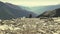 Slow motion zoom to lonely woman sitting on rocky terrain and watching the expansive view over the valley.