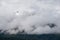 Slow moving clouds over the pine forest covered mountains