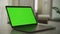 Slow optical zoom into a laptop computer screen with a green screen on it