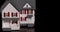 Slow panning of miniature model house on dark wood surface.