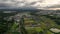 Slow pullback over rice fields and water storage pond on the edge of town