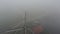 Slow reveal of dutch windmill in very foggy landscape
