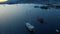 Slow rising shot over yachts in the sea showing resort bay with mountains against the sunset. Aerial footage
