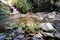 Slow shutter photo os a small natural waterfall formed with rocks in the river