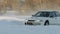 SLOW: Sport car turns on a winter ice road - close up