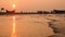 Slow time lapse of Sea beach water wave and dramatic nature sunset over boat unfocused tourist are around there