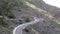 Slow vehicles driving carefully around a tight u-shaped on Spanish coast road through the mountains