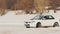 SLOW: White racing car drifts on an ice road in a race