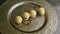 Slow zoom in at executive decorated four spherical sponge biscuits on golden plate