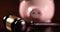 Slow zoom of piggy bank and gavel on dark wood surface.