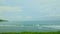 slowly panorama of blue ocean with strong white waves surrounded by green hills