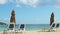 Slowly panorama on empty sandy ocean shore with beach chairs and closed umbrellas