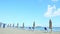 Slowly panorama at empty sandy seashore with beach chairs and closed umbrellas