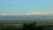 Slowly panorama on green valley with blue mountains and fluffy white clouds