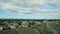 Slowly panorama at little city against fluffy white clouds above blue mountains