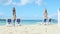 Slowly zoom out from empty sandy seashore with beach chairs and closed umbrellas