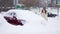 Slowmo woman cleans the car from snow. Winter is in the city and cars are covered with snowdrifts. A lot of