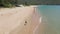 Slowmotion Aerial shot of a young woman running on a beautiful beach. Concept of healthy lifestyle and sports