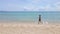 Slowmotion Aerial shot of a young woman running on a beautiful beach. Concept of healthy lifestyle and sports