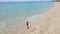 Slowmotion Aerial shot of a young woman running on a beautiful beach. Concept of healthy lifestyle and sports