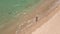 Slowmotion Aerial shot of a young woman running on a beautiful beach. Concept of healthy lifestyle and sports