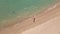 Slowmotion Aerial shot of a young woman running on a beautiful beach. Concept of healthy lifestyle and sports