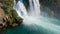 Slowmotion aerial video of the Lower Duden Waterfall in the city of Antalya. Camera tilts up from the sea water to the
