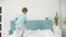 Slowmotion of cheerful toddler boy in pajamas jumping and running on big bed in parent\'s bedroom at morning.