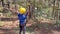 Slowmotion shot of a boy in a yellow helmet that is having fun in a rope climbing adventure park