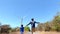 Slowmotion shot of a father and son running on a road leading to the wind electric generator. Investment in green energy