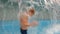 Slowmotion shot of a little boy having fun in a pool in a park