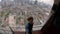 Slowmotion shot. Young man doing selfie sitting on the viewpoint with a view on the Kuala Lumpur city center. Travel to