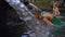 Slowmotion shot of a young woman visiting the holly springs in Indonesia. Tirta Empul holy water springs on the Bali