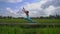 Slowmotion steadicam shot of a young woman practicing yoga on a beautiful rice field