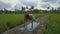 Slowmotion steadicam shot of a young woman with yoga math walking through a beautiful rice field