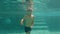 Slowmotion underwater shot of a happy kid having fun in a swimming pool. Healthy lifestyle concept